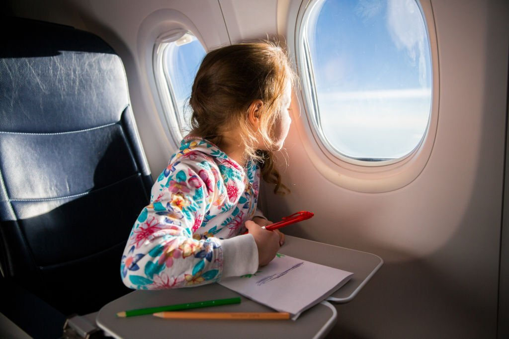 flight with kids, child coloring with crayons in airplane