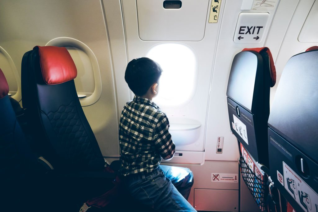 young boy and airplane window seat, traveling with kids