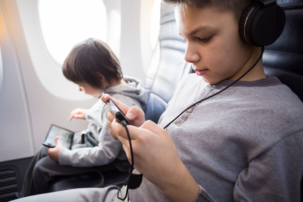 kids using smartphone on airplane, video gaming