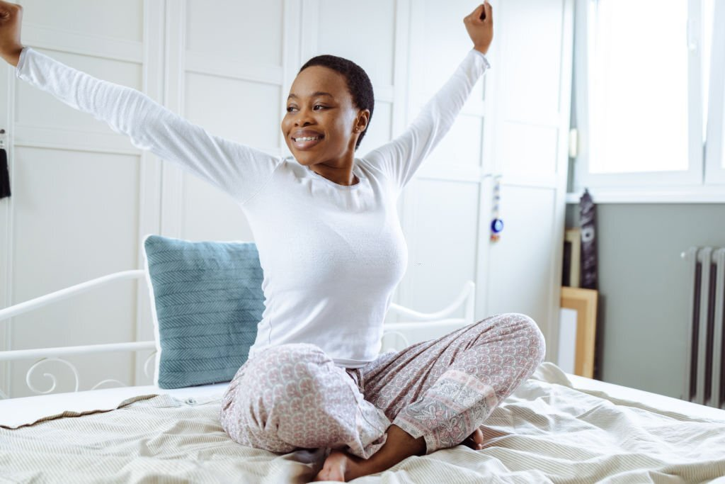 cheerful woman smiling in bed, morning energy