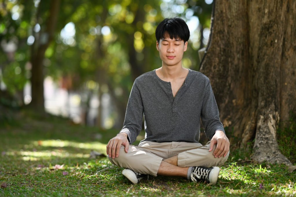 develop mindfulness, a person meditating outdoors