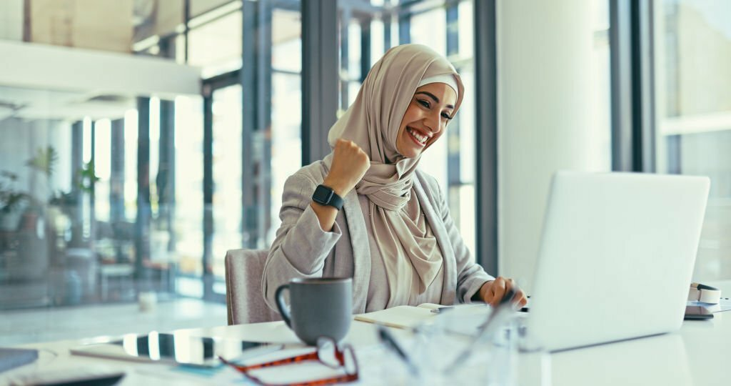 excited woman celebrating her success, start saving in your 20s